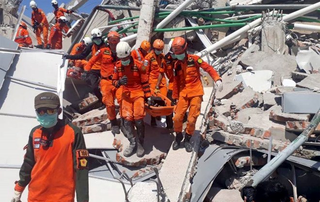 Một đội tìm kiếm-cứu nạn vận chuyển một nạn nhân từ đống đổ nát của một khách sạn ở Palu, đảo Sulawesi, Indonesia. (Nguồn: Reuters)
