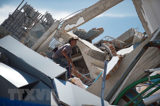 Tìm kiếm nạn nhân bị mắc kẹt dưới đống đổ nát của một khách sạn bị đổ sập sau trận động đất kèm theo sóng thần ở Sulawesi, Indonesia ngày 30/9/2018. (Nguồn: AFP/TTXVN)