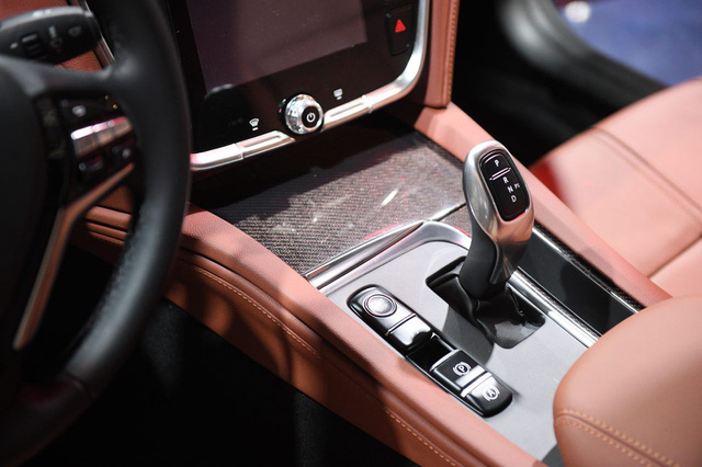  Ở cụm điều khiển trung tâm có chi tiết giống vật liệu sợi carbon, tạo cảm giác cao cấp cho khoang nội thất. Nút bấm khởi động được bố trí ở khu vực cần số, thay vì phía sau vô-lăng như thông thường. Cần số có thiết kế giống với nhiều mẫu xe BMW hiện nay.