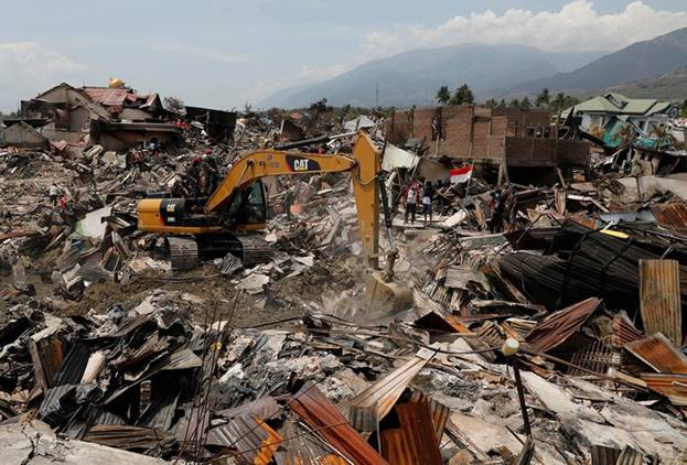  Nhưng chiếc xe cẩu được huy động để dọn dẹp đống đổ nát sau thảm họa thiên nhiên kinh hoàng ở Indonesia. Ảnh: Reuters