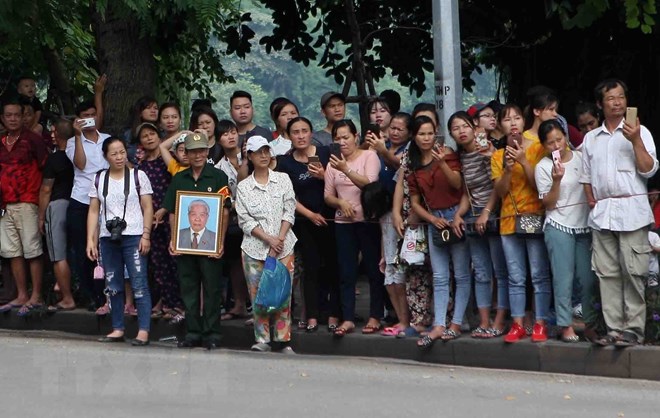  Người dân Thủ đô đưa tiễn linh cữu nguyên Tổng Bí thư Đỗ Mười trên đường Giải Phóng, trước cổng Bệnh viện Bạch Mai. (Ảnh: Dương Giang/TTXVN)