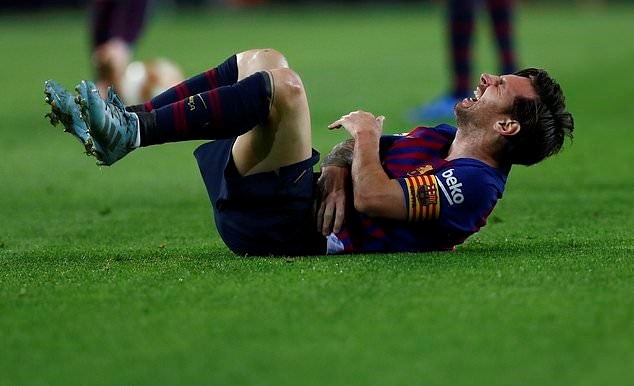 Messi đau đớn sau pha va chạm. Ảnh: AP