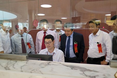 Phó Tổng Giám đốc VNPT Huỳnh Quang Liêm (áo vest) kiểm tra hệ thống công nghệ mà VNPT triển khai cho hai bệnh viện. (Ảnh: CTV/Vietnam+)
