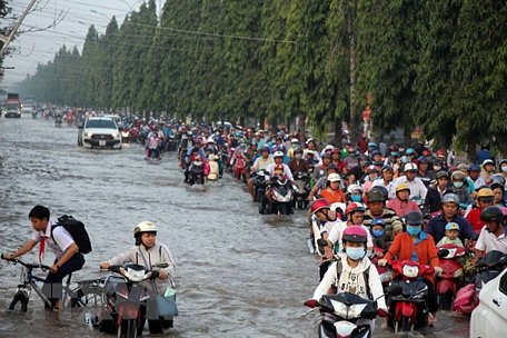 Đường Nguyễn Văn Cừ, quận Ninh Kiều bị ngập sâu, người dân gặp nhiều khó khăn khi di chuyển qua đây. (Ảnh: Thanh Liêm/TTXVN)