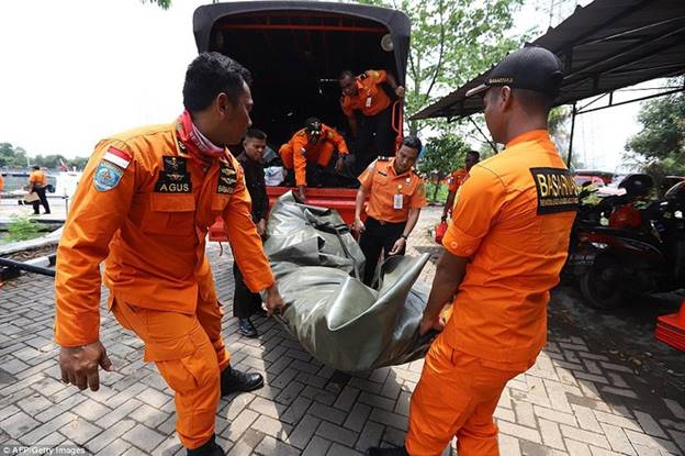 Thi thể của một nạn nhân trong vụ rơi máy bay được các nhân viên cứu hộ chuyển khỏi xe tải. Ảnh: AFP/Getty.