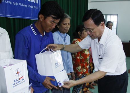 Ông Huỳnh Vĩnh Phúc- Chánh văn phòng Công ty Điện lực Vĩnh Long trao quà cho gia đình chính sách ở xã Tân Hưng.