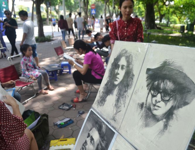 Nhiều du khách đều tranh thủ nhờ các họa sĩ vẽ một bức ký họa làm kỷ niệm chuyến thăm Hồ Gươm.