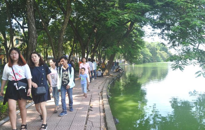 Người dân Thủ đô thong thả dạo bộ ngắm cảnh ven Hồ Gươm.
