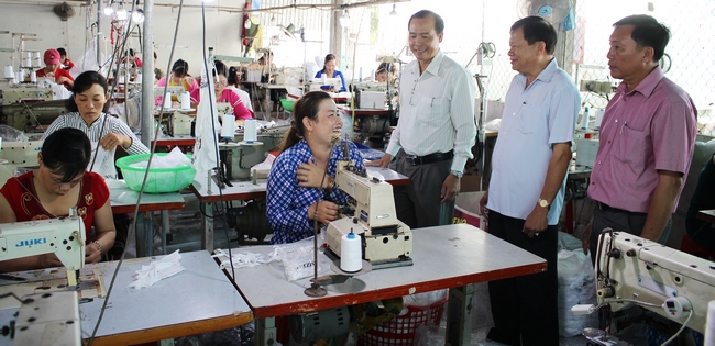 Ông Lê Quang Đạo (thứ 2, bên phải) ân cần thăm hỏi đời sống việc làm của các lao động tại cơ sở may gia công. 