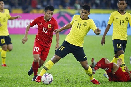  Các cầu thủ Malaysia (áo vàng) đã thi đấu rất vất vả trước Lào (áo đỏ)
