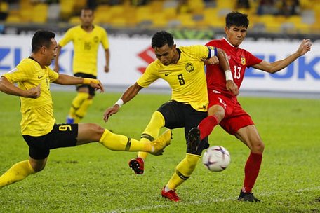 Các cầu thủ Malaysia (áo vàng) đã thi đấu rất vất vả trước Lào (áo đỏ)