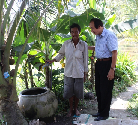 Ông Lương Phan Cừ- Chủ tịch Hội Bảo trợ người khuyết tật và trẻ mồ côi Việt Nam (phải) đến thăm gia đình chú Lê Văn Mỹ (ấp An Phước, xã Trung An- Vũng Liêm) vừa được kéo nước sạch đến nhà.