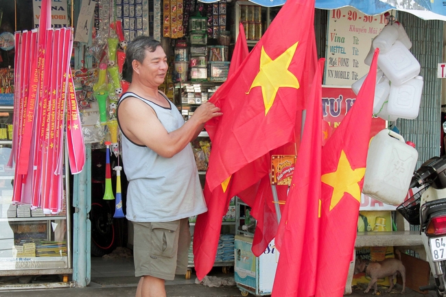 Trong khi tại một cửa hàng trên đường Nguyễn Huệ (Phường 2), những lá cờ Tổ quốc Việt Nam được trưng bày, chuẩn bị cho trận đấu tối nay.