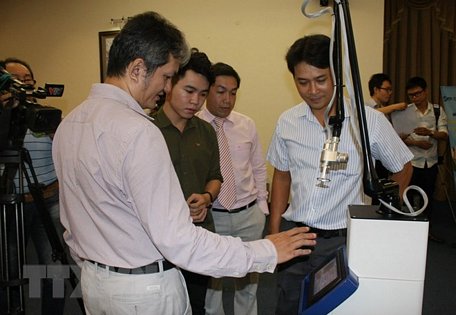 Đại diện Công ty Lascitec giới thiệu về thiết bị phẫu thuật ứng dụng công nghệ laser vi điểm do kỹ sư Việt Nam thiết kế, chế tạo. (Ảnh: Tiến Lực/TTXVN)