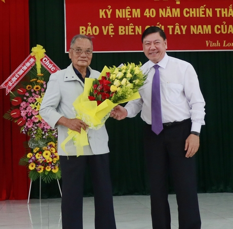 Đồng chí Trần Văn Rón tặng hoa cho đồng chí Nguyễn Ký Ức- nguyên Bí thư Tỉnh ủy Cửu Long, nguyên Đoàn trưởng Đoàn Chuyên gia (giai đoạn 1).