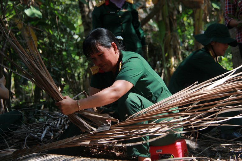 Các nữ bộ đội thì phụ giúp người dân róc lá dừa, làm cỏ, dọn vườn.