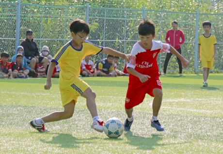 Pha tranh bóng trận tranh hạng ba, giữa Trường Tiểu học Sư phạm Thực hành (áo đỏ) trước Tiểu học Trần Đại Nghĩa.
