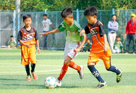 Pha tranh bóng trận chung kết giữa Trường Tiểu học Lê Lợi (áo cam) và Trường Tiểu học Phạm Hùng.