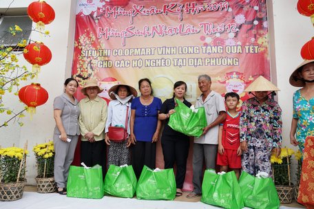 Bà Nguyễn Thị Đào-Phó Chủ tịch UBND Phường 1 và bà Diệp Thị Quế Hương- Phó Giám đốc Siêu thị Co.opmart Vĩnh Long trao quà cho hộ nghèo.