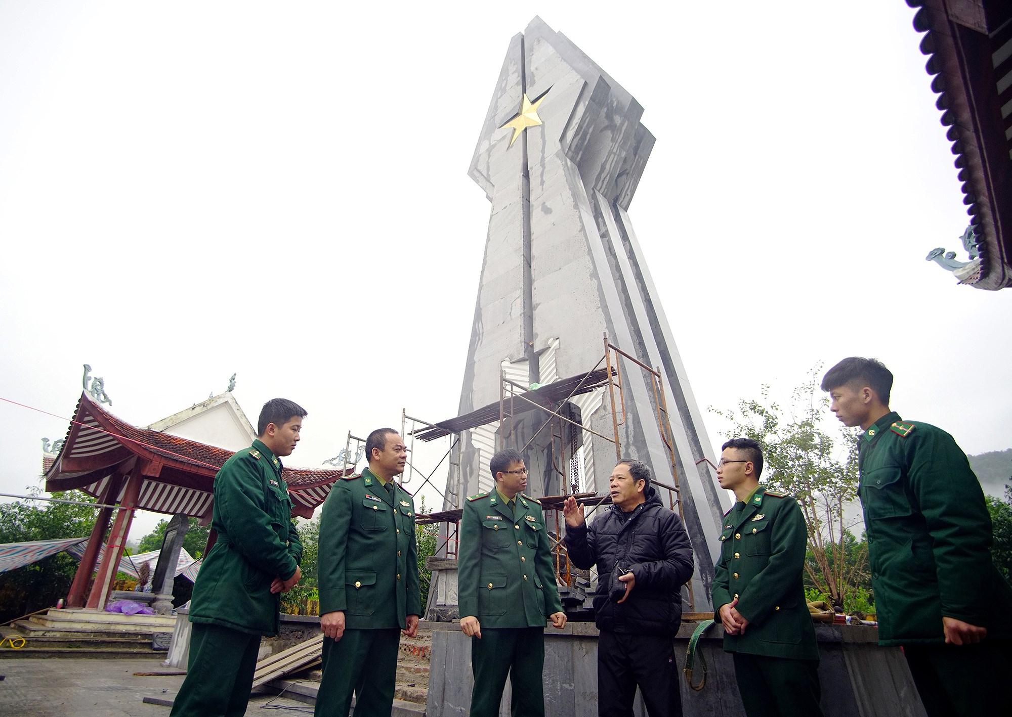 Ông Hoàng Như Lý (thứ ba từ phải sang) và cán bộ, chiến sĩ Đồn biên phòng Pò Hèn trò chuyện bên Tượng đài kỷ niệm Pò Hèn