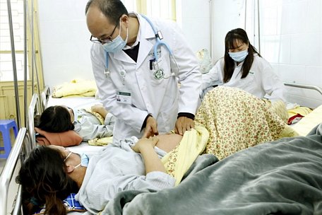 PGS. TS Đỗ Duy Cường - Trưởng khoa Truyền nhiễm, Bệnh viện Bạch Mai đang thăm khám cho bệnh nhân sởi điều trị tại khoa.