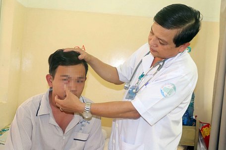  BS CKII Nguyễn Thanh Phong (Bệnh viện Bệnh nhiệt đới TP.HCM) đang khám cho cháu N.T.P. - Ảnh: X.MAI