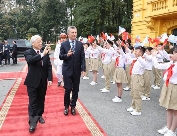 Tổng Bí thư, Chủ tịch nước Nguyễn Phú Trọng và Tổng thống Argentina Mauricio Macri vẫy chào thiếu nhi Việt Nam tại lễ đón chính thức. (Ảnh: Trí Dũng/TTXVN)