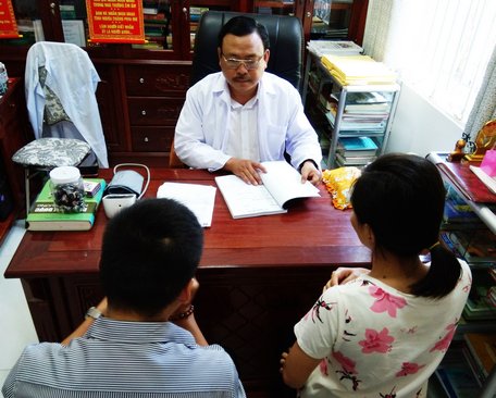 BS Nguyễn Phú Lâm đang xem hồ sơ và tư vấn cho một cặp vợ chồng hiếm muộn.