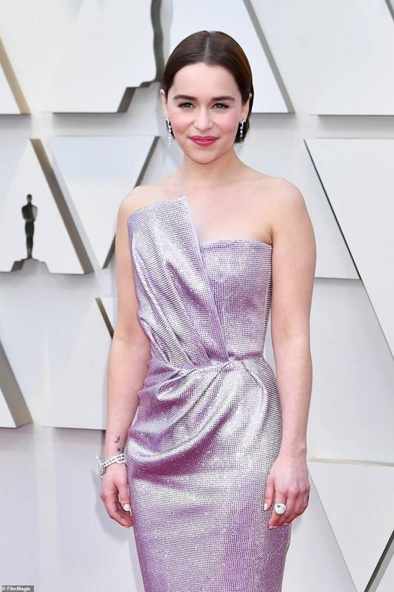 Emilia Clarke xinh đẹp khi diện chiếc đầm cúp ngực ánh tím - thiết kế của Balmain. Kiểu tóc ngắn chải mượt cùng lối trang điểm tông hồng giúp nữ diễn viên tỏa sáng trên thảm đỏ.