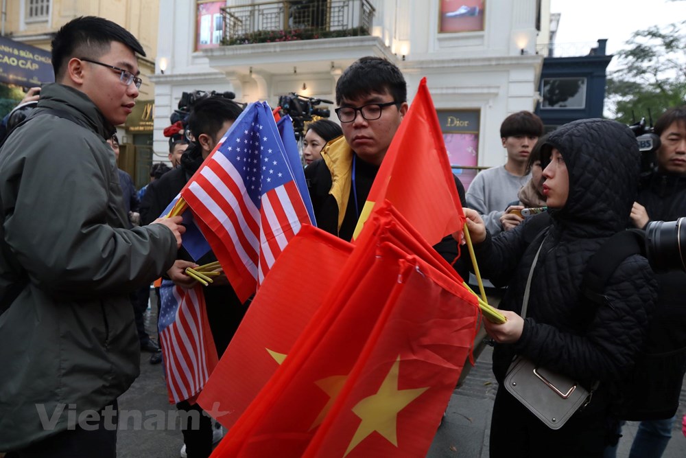  Quốc kỳ Việt Nam, Mỹ, Triều Tiên được các bạn trẻ chuyền tay nhau từ sớm 26/2. (Ảnh: Minh Sơn/Vietnam+)