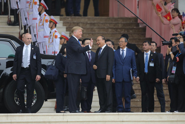  Tổng thống Trump và Thủ tướng Nguyễn Xuân Phúc vẫy tay chào nhân viên Văn phòng Chính phủ vẫy cờ hoa chào đón - Ảnh: VIỆT DŨNG
