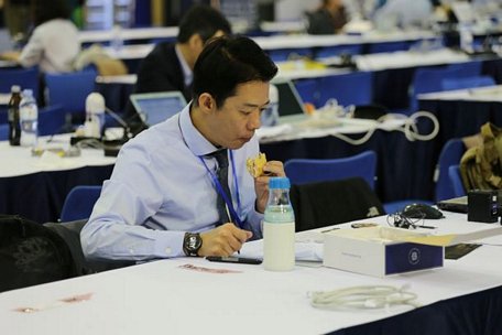 Một phóng viên Hàn Quốc vừa ăn sáng vừa làm việc. Ảnh: Thu Hằng