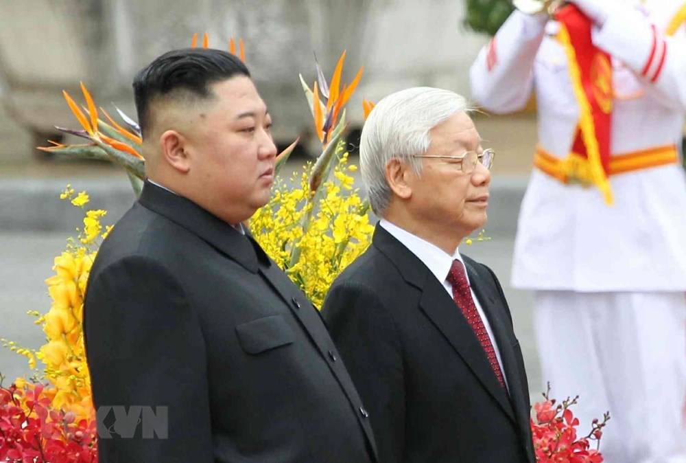  Tổng Bí thư, Chủ tịch nước Nguyễn Phú Trọng và Chủ tịch Triều Tiên Kim Jong-un trên bục danh dự, thực hiện nghi lễ chào cờ. (Ảnh: Văn Điệp/TTXVN)