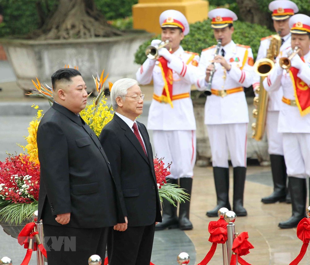  Tổng Bí thư, Chủ tịch nước Nguyễn Phú Trọng và Chủ tịch Triều Tiên Kim Jong-un trên bục danh dự, thực hiện nghi lễ chào cờ. (Ảnh: Văn Điệp/TTXVN)