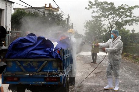 Các lực lượng chức năng phun thuốc, khử trùng các phương tiện ra vào xã Trực Thắng, huyện Trực Ninh. Ảnh: Văn Đạt/TTXVN