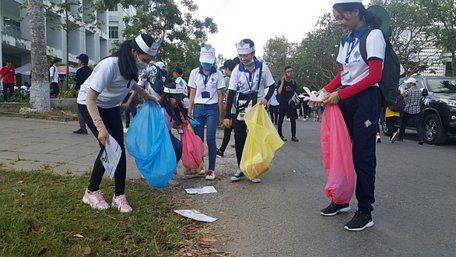 Các sinh viên tình nguyện nhặt rác tại khuôn viên Trường ĐH Cần Thơ ngày 10-3 - Ảnh: CHÍ CÔNG