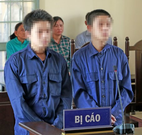 Các bị cáo Trung, Nghĩa (từ trái qua) nghe tòa tuyên án.