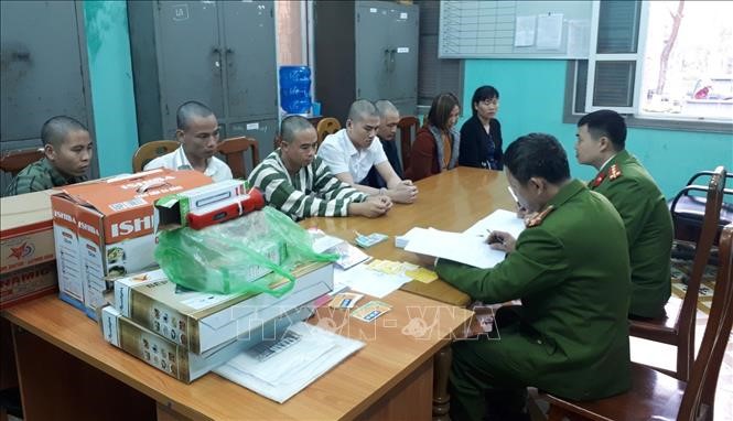 Các đối tượng lừa đảo cùng tang vật bị thu giữ tại Cơ quan điều tra Công an thị xã Quảng Yên, tỉnh Quảng Ninh. Ảnh: TTXVN phát