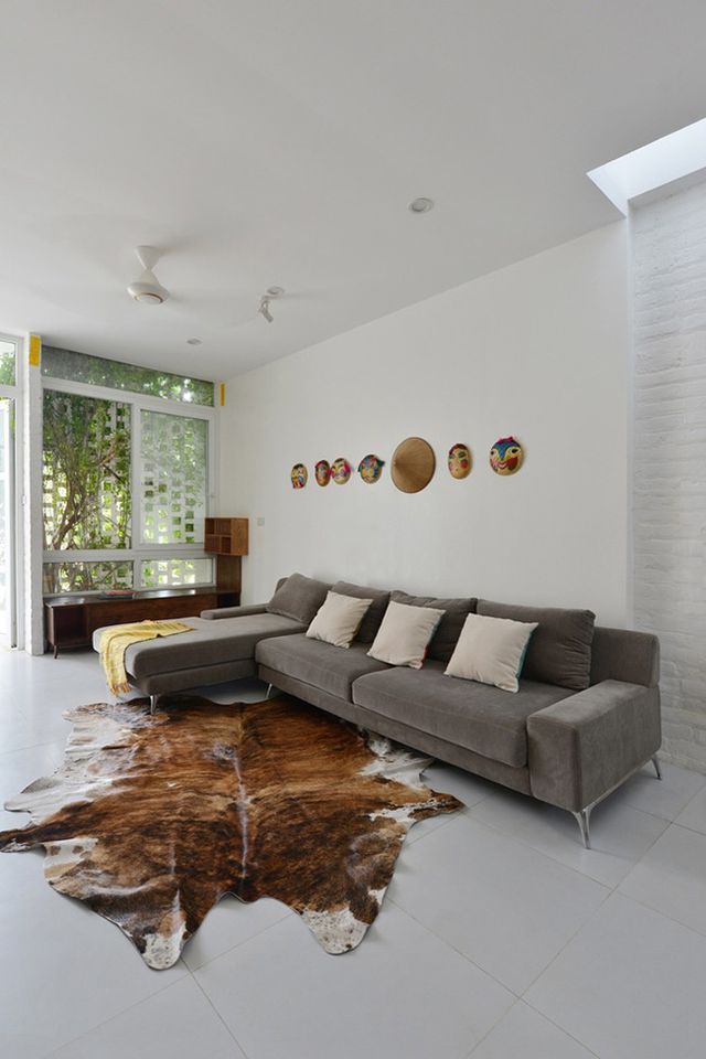 Phòng khách hiện đại với bộ sofa màu ghi sáng và thảm trải sàn màu da bò.