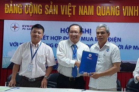 Đại diện Công ty Điện lực Sài Gòn trao hợp đồng mua điện cho hộ dân lắp đặt hệ thống điện mặt trời áp mái. Ảnh Nam Dương