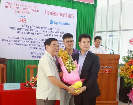 Ông Trần Hoàng Tựu- Phó Chủ tịch UBND tỉnh (bên trái) tặng hoa cho đại diện nhà đầu tư.