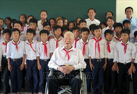 Đại tướng Lê Đức Anh chụp ảnh lưu niệm với các em học sinh Trường THPT Nam Yên, huyện An Biên (Kiên Giang). Ảnh: TTXVN phát