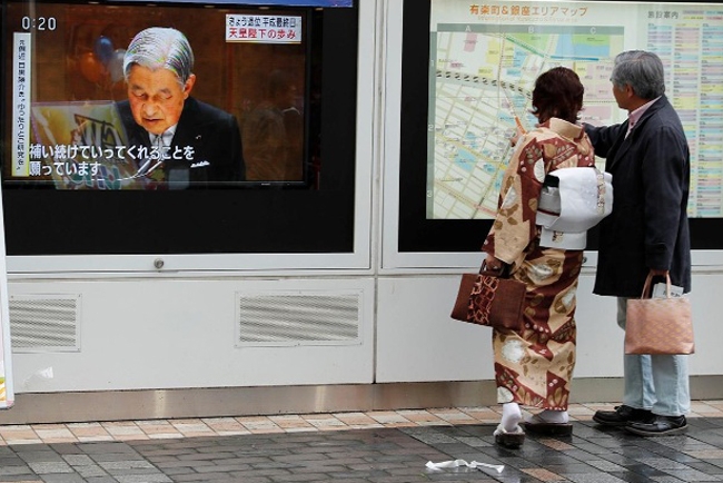 Người dân Nhật Bản theo dõi bản tin về Nhật hoàng Akihito.