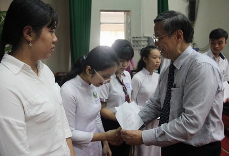  Ông Lê Vinh- Phó tổng Giám đốc Công ty CP Tiến bộ quốc tế AIC trao học bổng “Chương trình 9999 Tết” cho các em học sinh.
