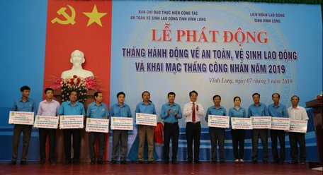 Phó Chủ tịch UBND tỉnh- Lữ Quang Ngời (thứ 6 từ phải sang) trao bảng tặng nhà “Mái ấm Công đoàn” cho các đơn vị.