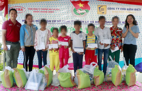  Bà Lê Ngọc Thúy- Phó Tổng biên tập Báo Vĩnh Long (bìa phải) và Bí thư chi đoàn Công ty quản lý và kinh doanh chợ Bình Điền- Phạm Hoàng Giang (bìa trái) trao quà cho các trẻ.