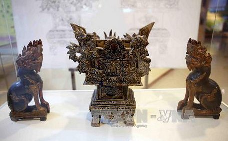 Hình tượng con nghê của Việt Nam trên lư hương bằng gốm thế kỷ XIX và nghê bằng gỗ thế kỷ XIX được trưng bày tại một triển lãm. Ảnh: Trần Lê Lâm/TTXVN