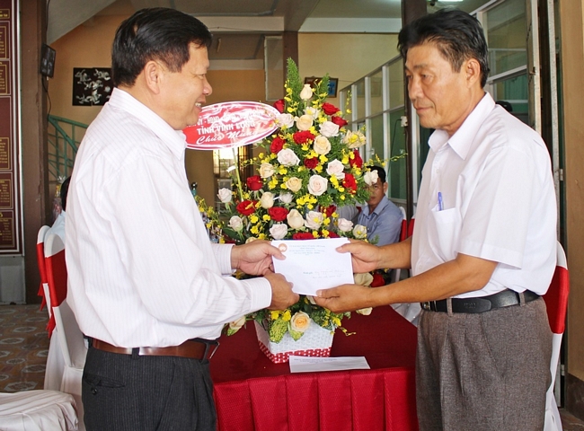 Chủ tịch Ủy ban MTTQ Việt Nam tỉnh Vĩnh Long Lê Quang Đạo (trái) trao tặng hoa và quà đến Ban Đại diện Phật giáo Hòa Hảo tỉnh.