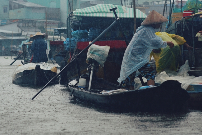 Người nông dân đang chằng buộc che chắn cho ghe thuyền của mình trước một cơn mưa bất chợt đổ xuống Ngã Năm.