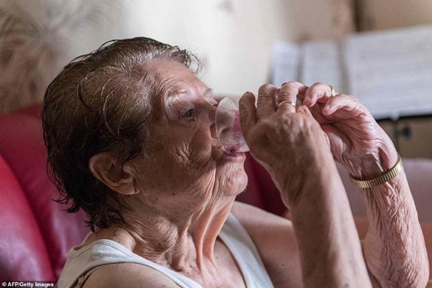 Những người dân châu Âu được khuyến cáo tránh ánh nắng mặt trời gay gắt và uống nhiều nước để đảm bảo sức khỏe. Trong ảnh là một người già ở Clermont-Ferrand, Pháp đang uống nước. Ảnh: AFP